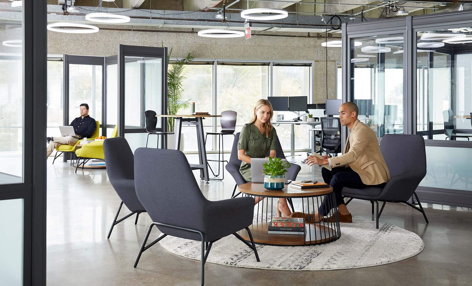 3 professionals working in open office environment with halo pendants for lighting