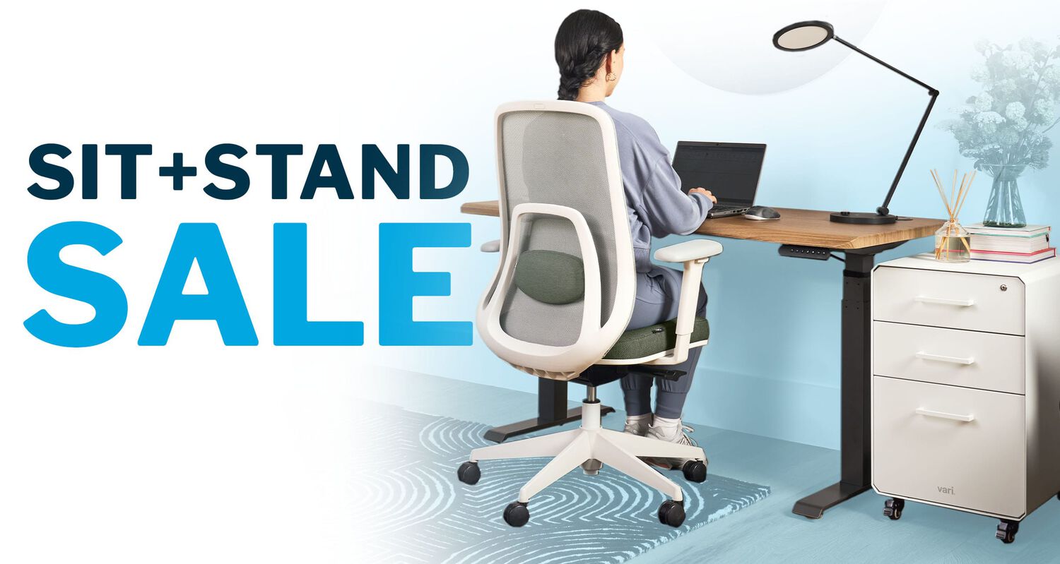 sit stand sale displaying vari standing desk and ascent chair and studio lamp