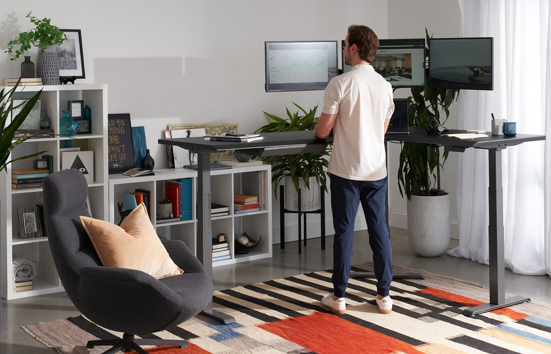 L-Shape electric standing desk setup in the corner of an open workspace