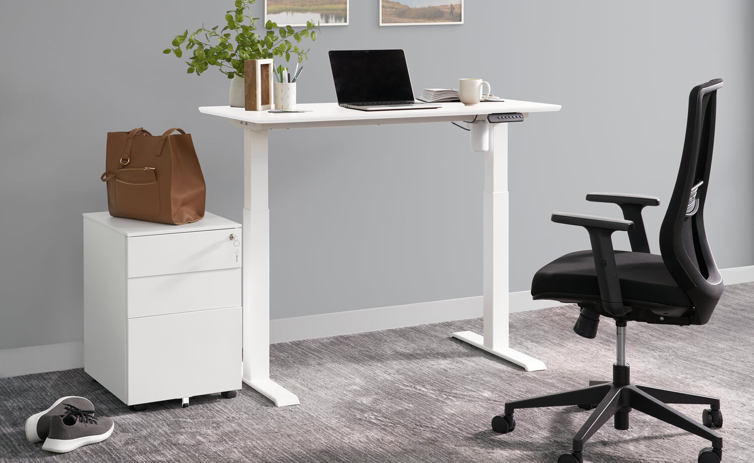 essential electric standing desk 48 by 24 in white paired with an essential file cabinet in white and essential task chair setup in home officed