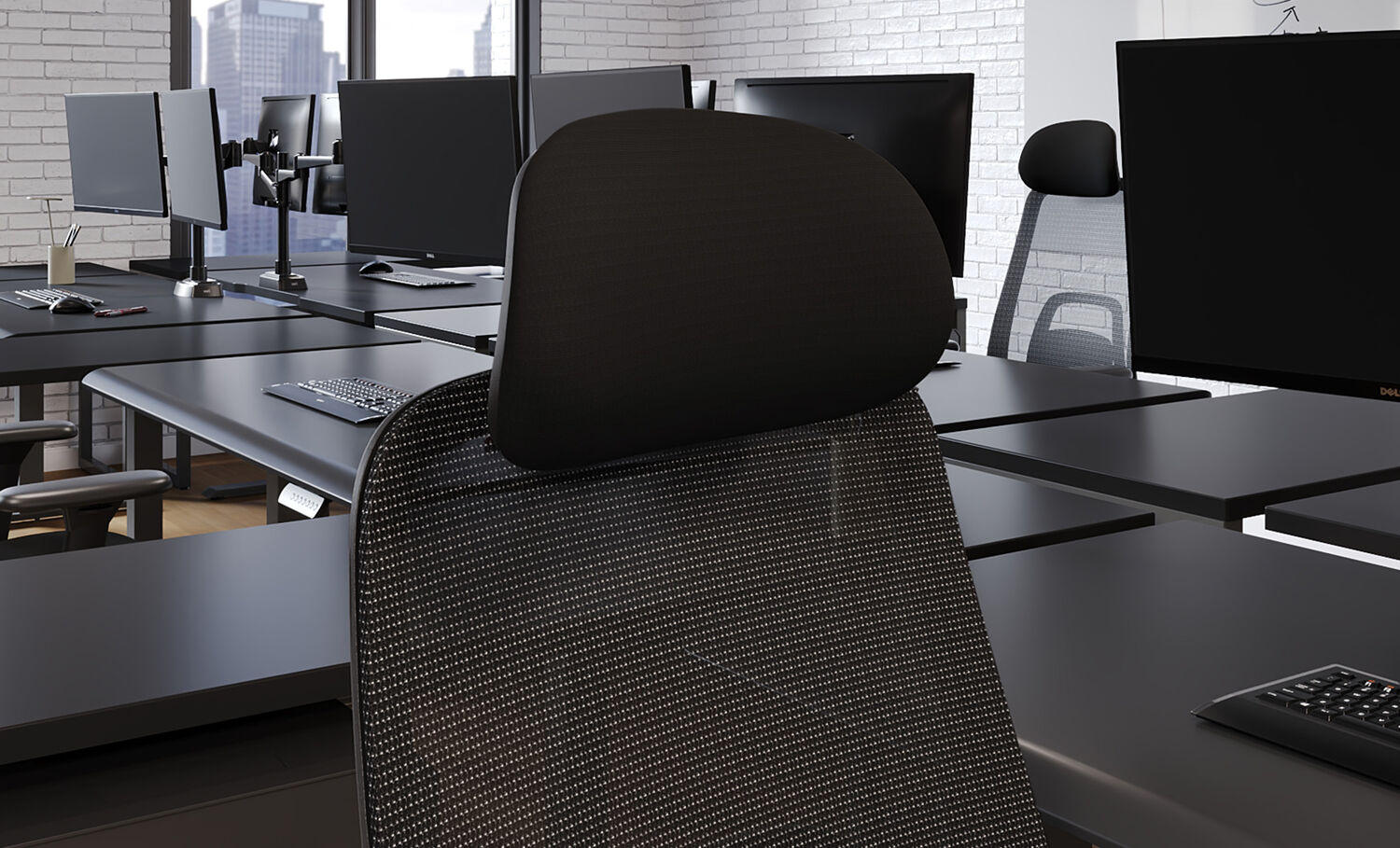 Black fabric headrest attached to a mesh office chair, shown in an open office with multiple desks, dual monitor arms, and Dell monitors.