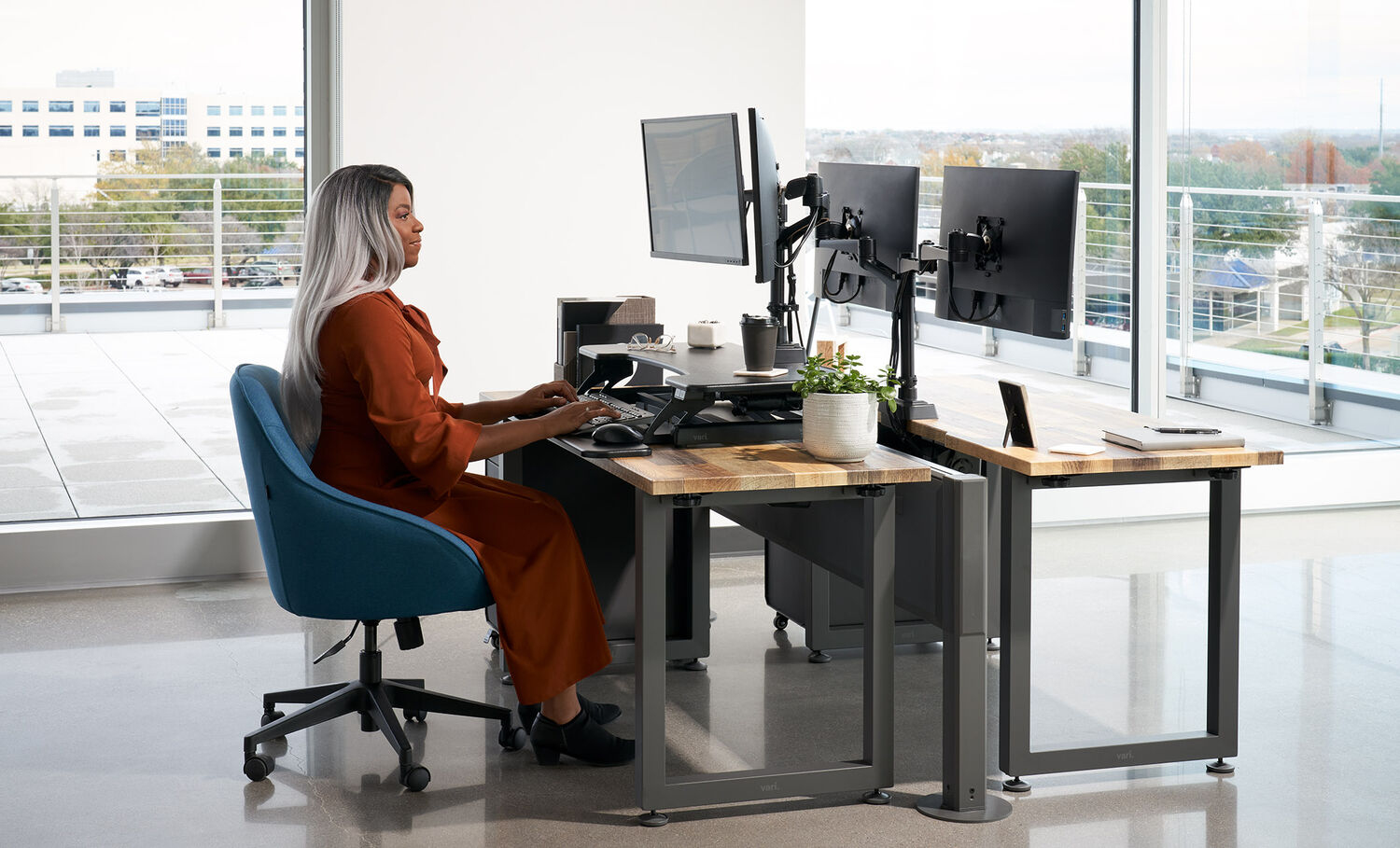 professional sitting at a desk working at an electric desk converter