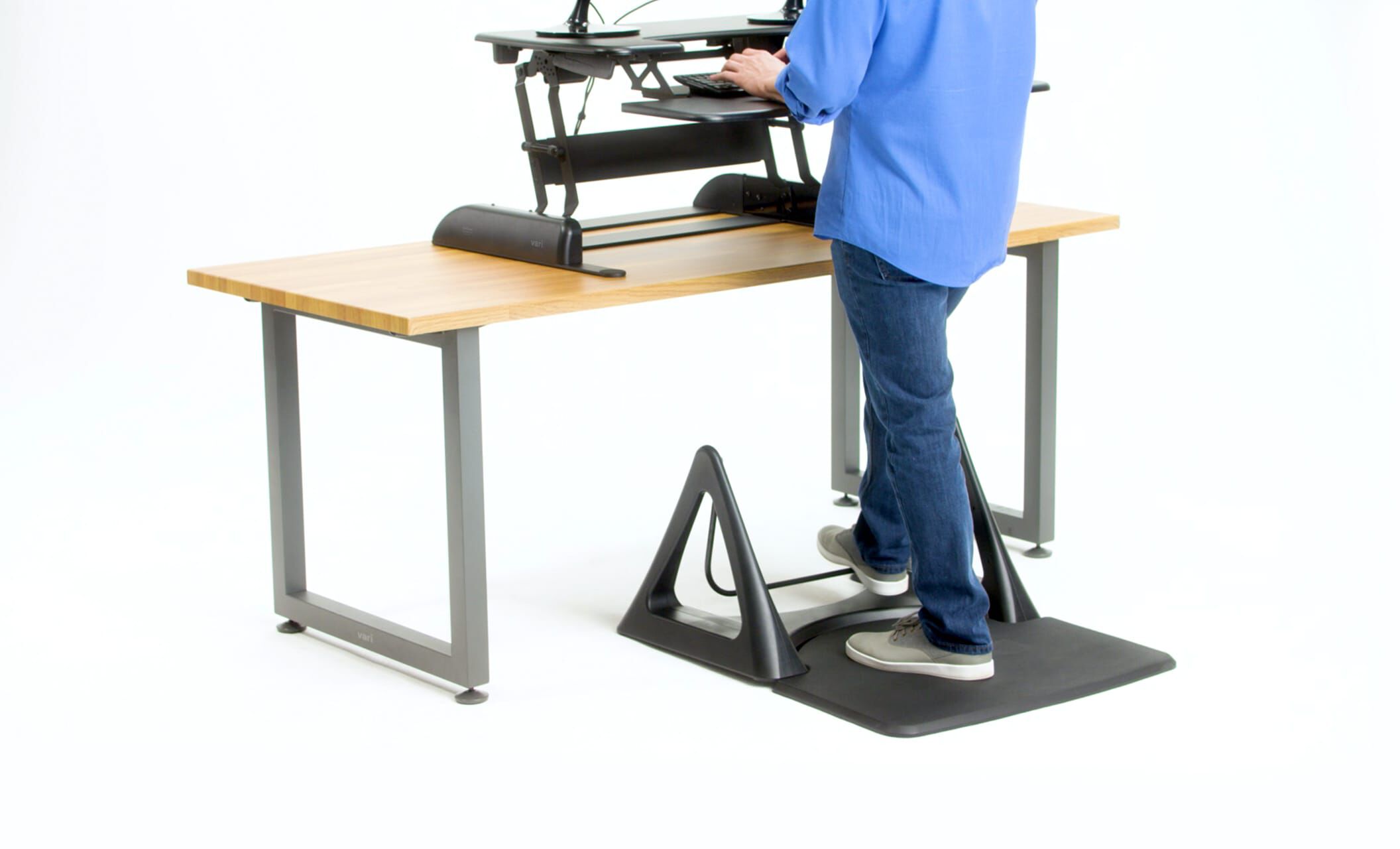 Individual using Vari Active mat rocker and desk converter