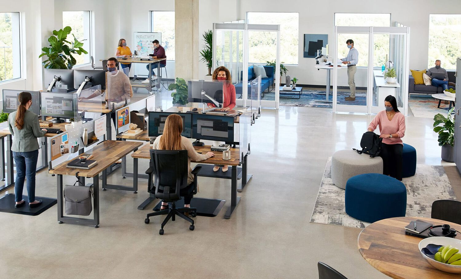 open office with Vari products as seen from above, with employees working in various areas including benched desks, private offices, and conference rooms