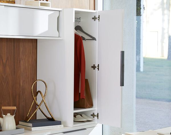 executive wardrobe shown open with hanging clothes and shoes inside