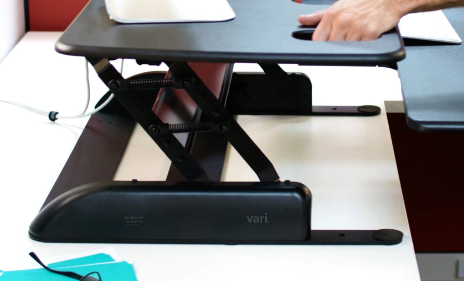 Sideview of converter being raised by user in an office setting on exsisting desk