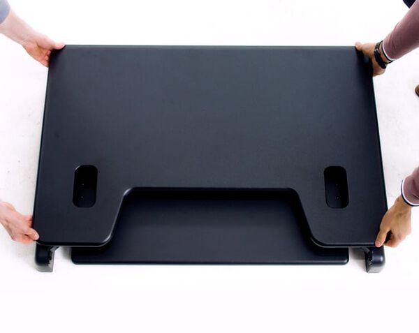 Individuals adjusting VariDesk Cube Plus 40 to seated position