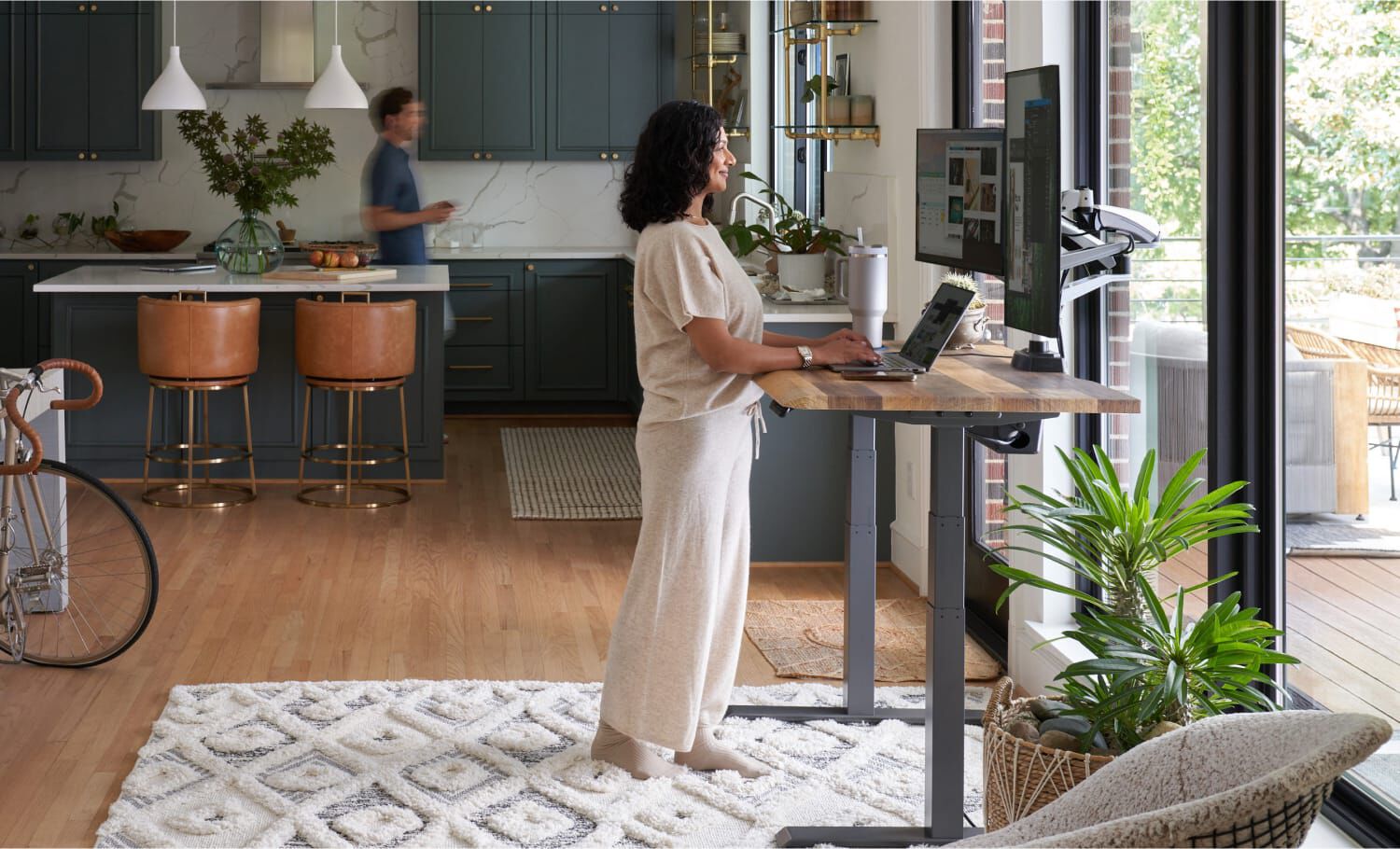Individual standing at standing desk in home setting