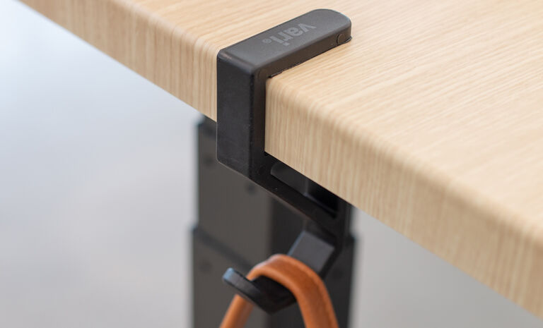 Desk Hook clamped to a desk or table shown holding a bag strap