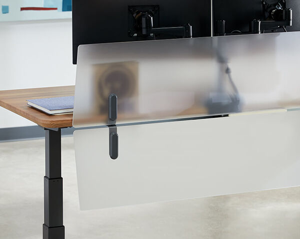 close up of two acrylic modesty panels attached to a desk