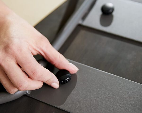 Individual tightens clamp on Wood Conference Chair to assemble