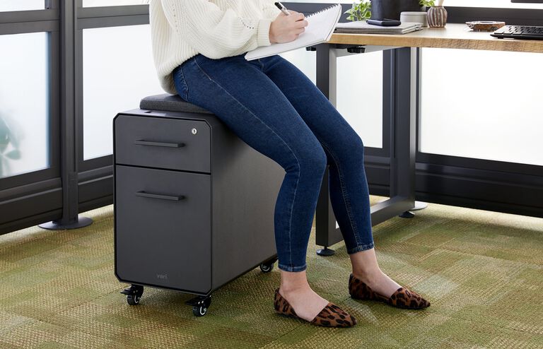 individual sitting on vari slim storage seat