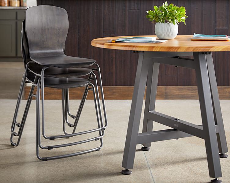 Table seen next to stacked chairs in office breakroom