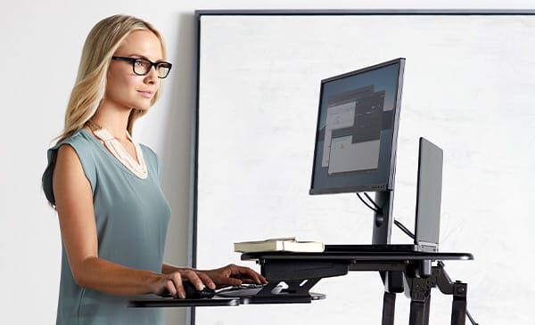 professional standing while working with monitors at an ergonomic height