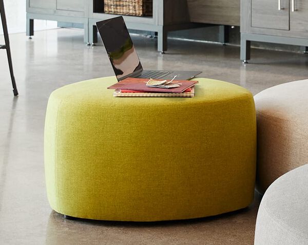 small ottoman with laptop and notebook on top