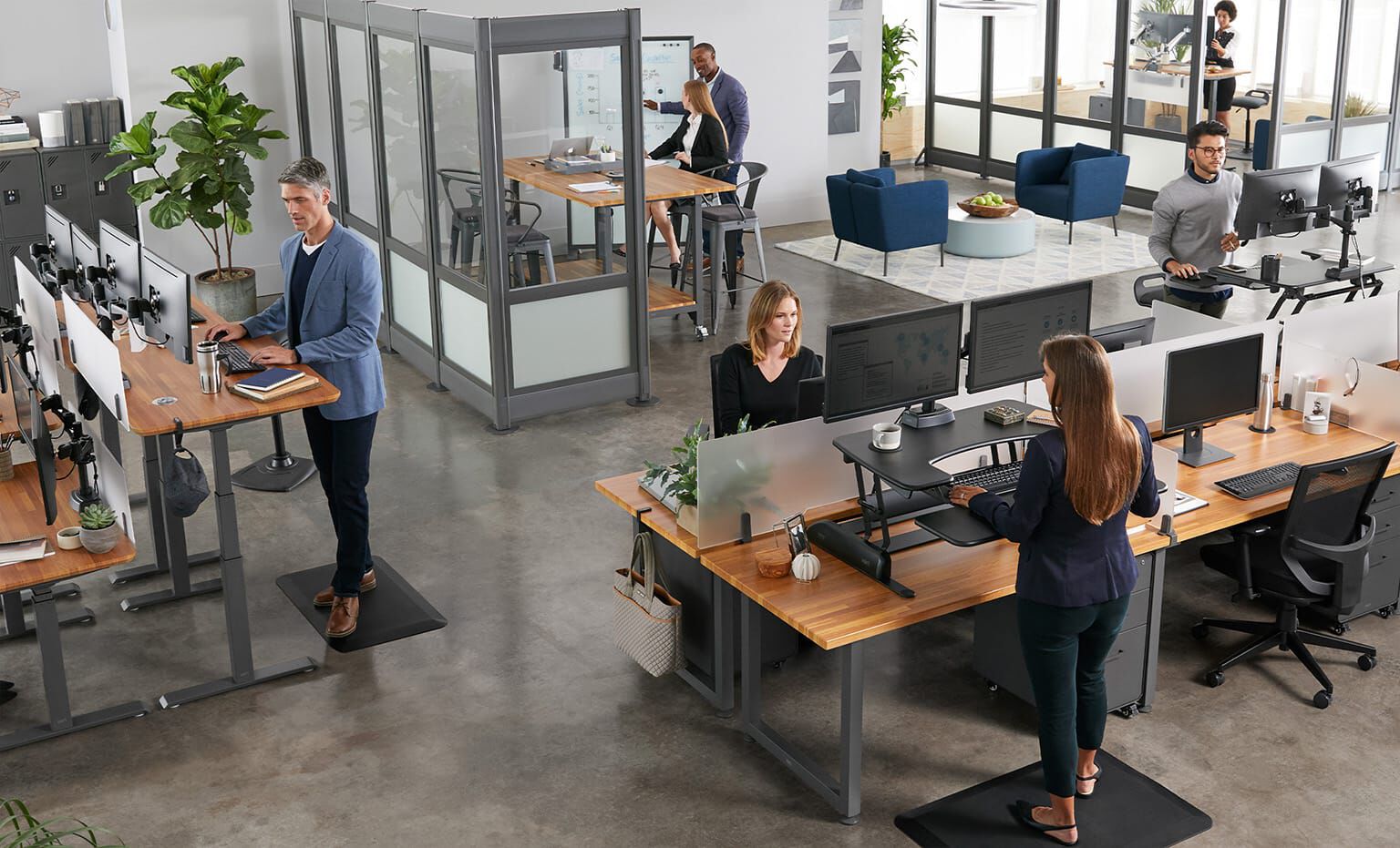 open office with Vari products as seen from above, with employees working in various areas including benched desks, private offices, and conference rooms