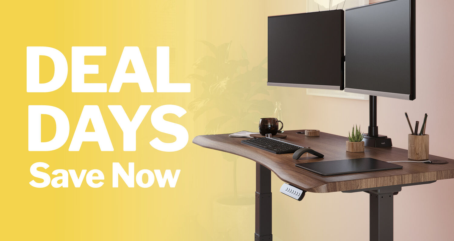 woman sitting and working at an electric standing desk