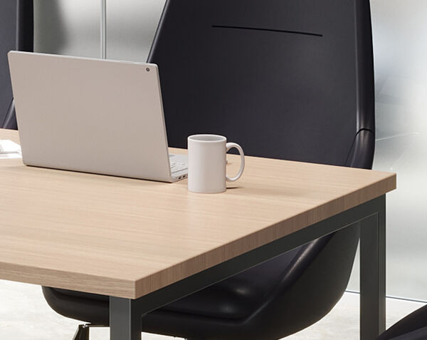laptop and mug in work space sitting on standing conference table