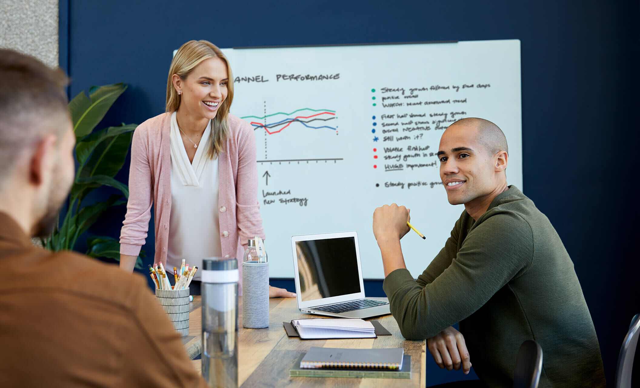 vari glass board mounted in a conference room with people meeting