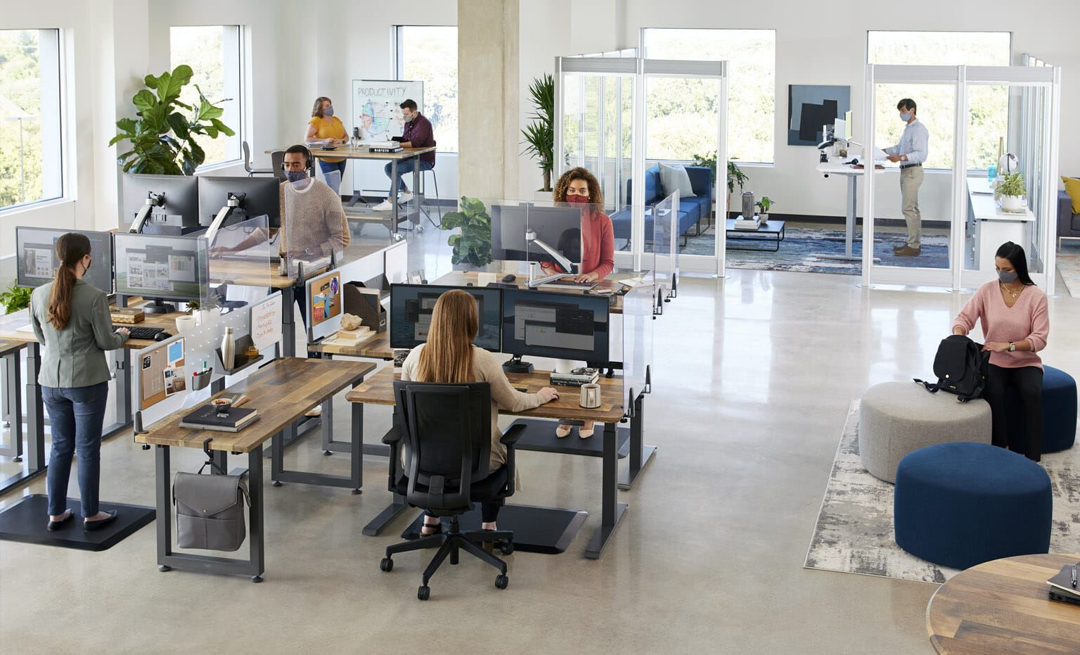 open office with Vari products as seen from above, with employees working in various areas including benched desks, private offices, and conference rooms