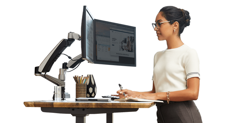standing desk in use with dual monitor arms