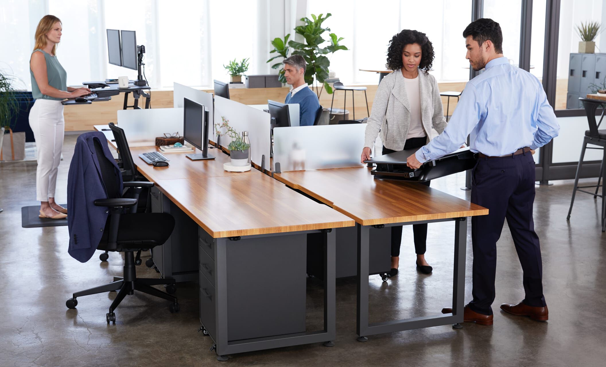 varidesk standing desk converter being set atop a fixed height desk