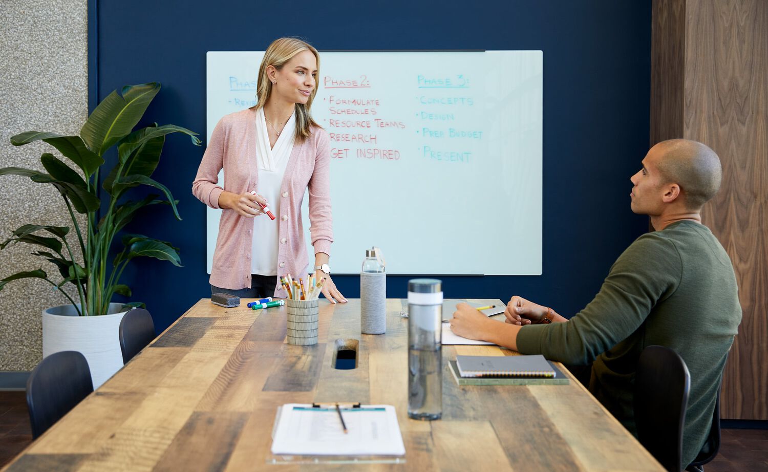 Professional leading meeting at seated conference table