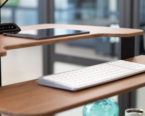 close up view of varidesk premier electric keyboard stand with a keyboard used on the shelf