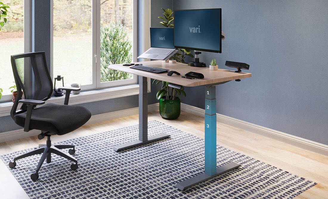 Vari Electric Standing desk in light wood in home office setting