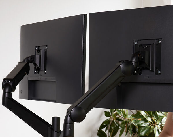 close up view of the back of the dual monitor arms that sit into the monitor screens