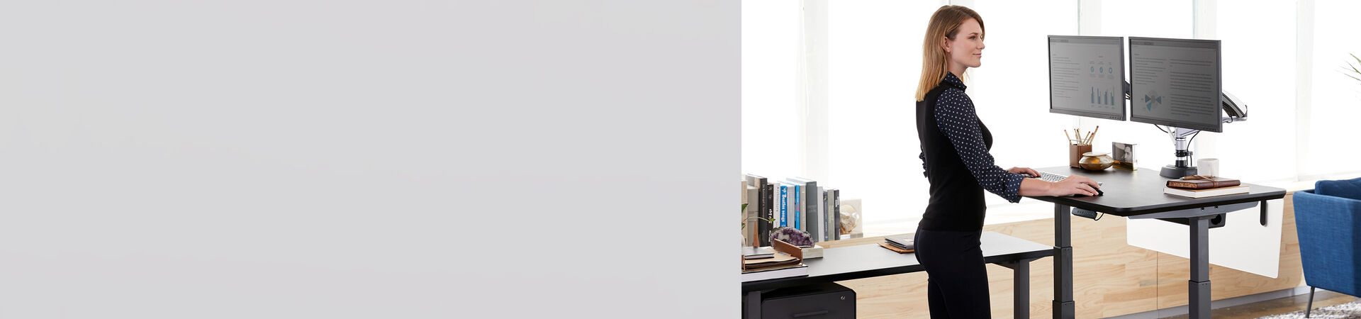 Professional using a Vari Electric standing desk in office setting