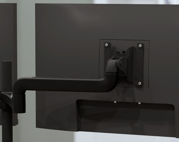 Close-up of a dual monitor arm's mounting plate attached to the back of a monitor, showing the pivot joint and VESA mounting screws.