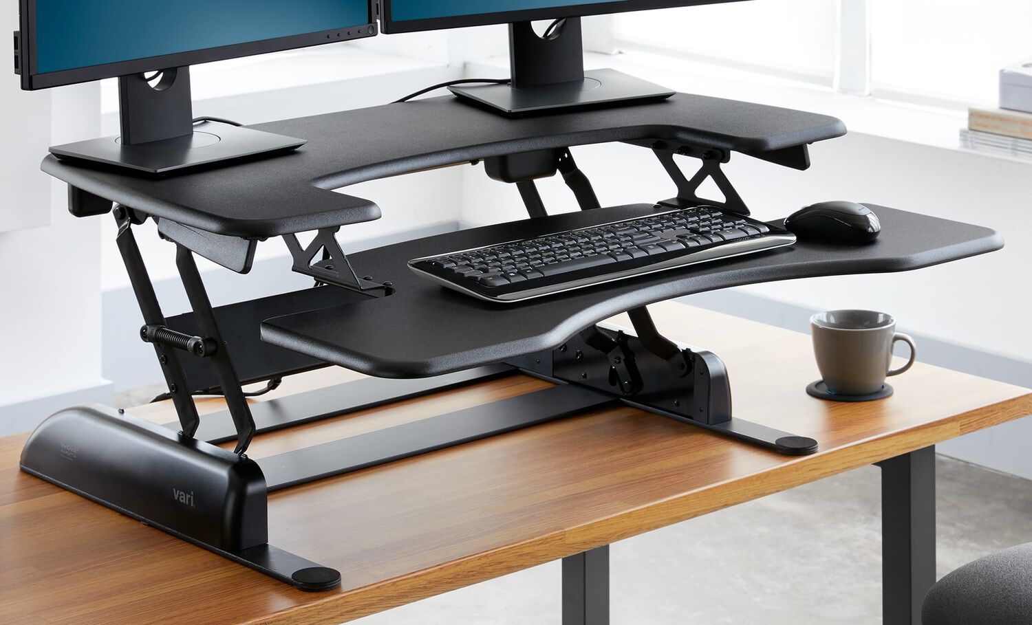 Individual is standing at a raised converter ontop of a desk working in an office setting