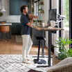 active seat placed under an electric standing desk when not in use in a home office setting 