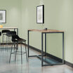 standing work table in reclaimed wood finish setup in an open workspace environment with a tall side chair and laptop in use on top of the table