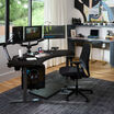 A modern, stylish home office setup featuring a curved desk with triple monitors, ergonomic chair, desktop PC, and a cozy workstation with vintage cameras and a turntable in the background.