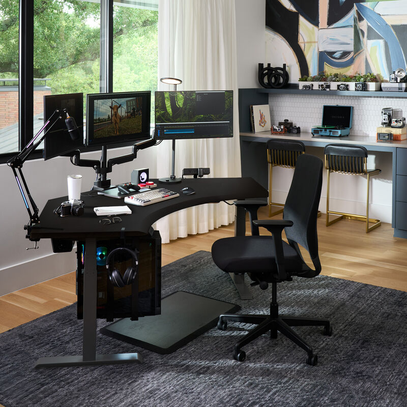 A modern, stylish home office setup featuring a curved desk with triple monitors, ergonomic chair, desktop PC, and a cozy workstation with vintage cameras and a turntable in the background. image number null