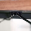 clips attached to the bottom of a desk securing a power cable
