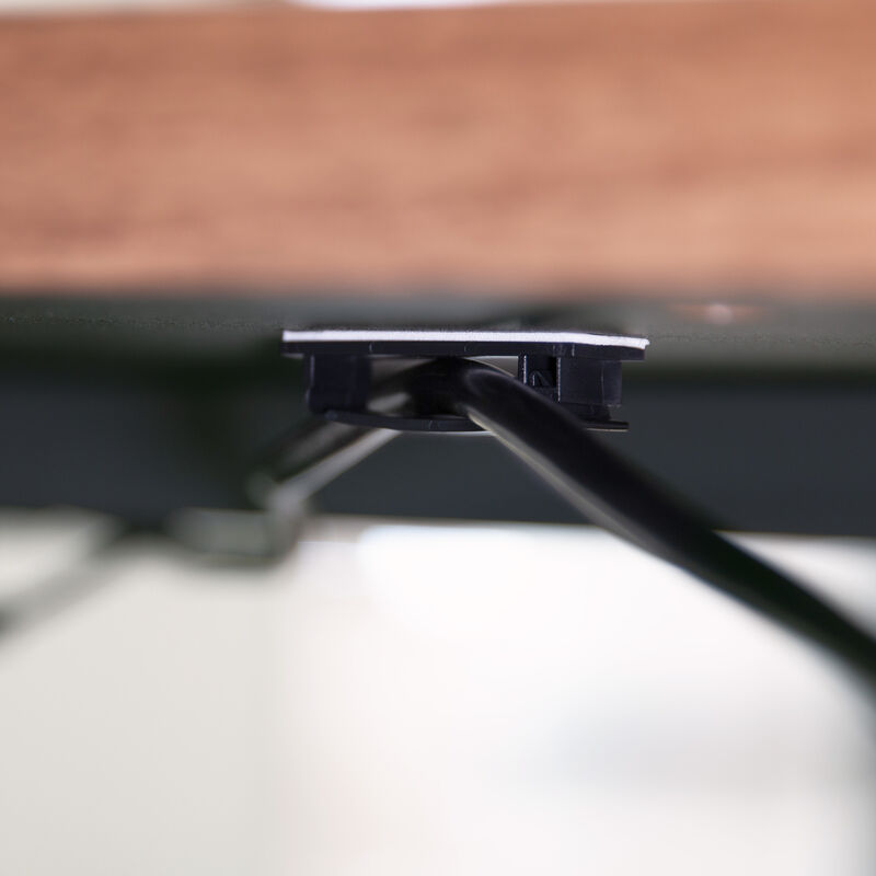 clips attached to the bottom of a desk securing a power cable image number null