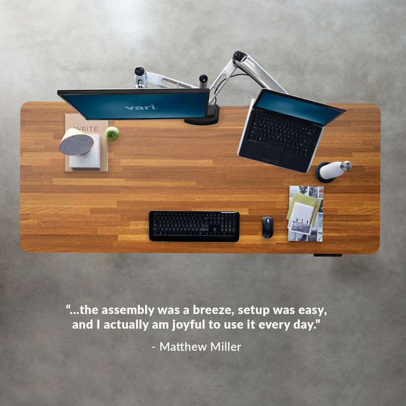 overhead image of an electric standing desk with a quote underneath reading, the assembly was a breeze setup was easy and I actually am joyful to use it everyday image number null