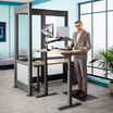 professional works at electric standing desk in silver private office 