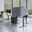 backside of the tall privacy desk surround in light grey felt on an electric standing desk in a workspace