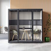 two person privacy booth in the black finish against a wall in an office with furniture inside of it