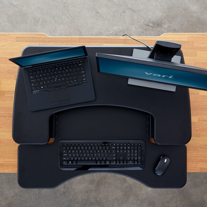 Overhead view of the VariDesk Pro Plus 30 Black sit-stand desk converter lowered on a wooden desk image number null