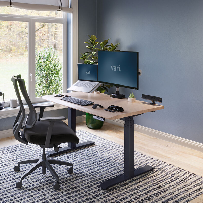 electric standing desk with comfortedge in 48x30 light wood top and black legs in lowered position at home image number null