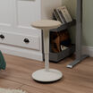 balance stool sitting in front of an electric standing desk in a home office in a raised position