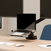 laptop sitting on top of the laptop holder installed on a desk