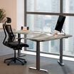 driftwood electric standing desktop with slate legs in an office setting in a lowered position