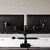 Dual-Monitor Arm 180° Black mounted to desk with two monitors installed