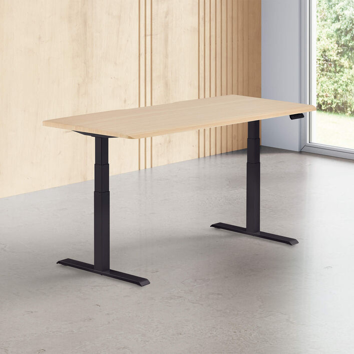 light wood finish standing desk top with black legs in a open office image number 0